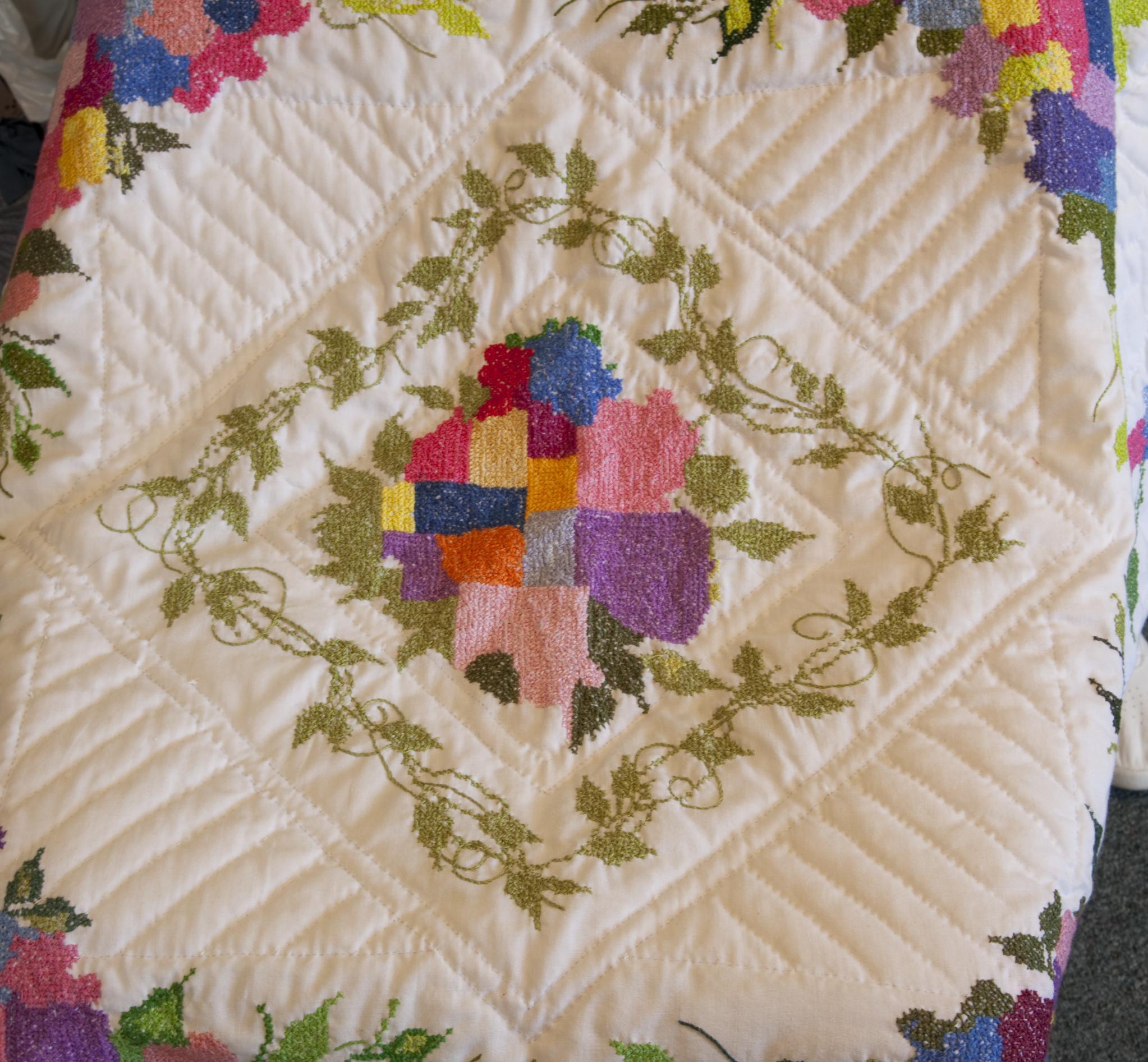 Off-white quilt with vines and flowers and central diamond