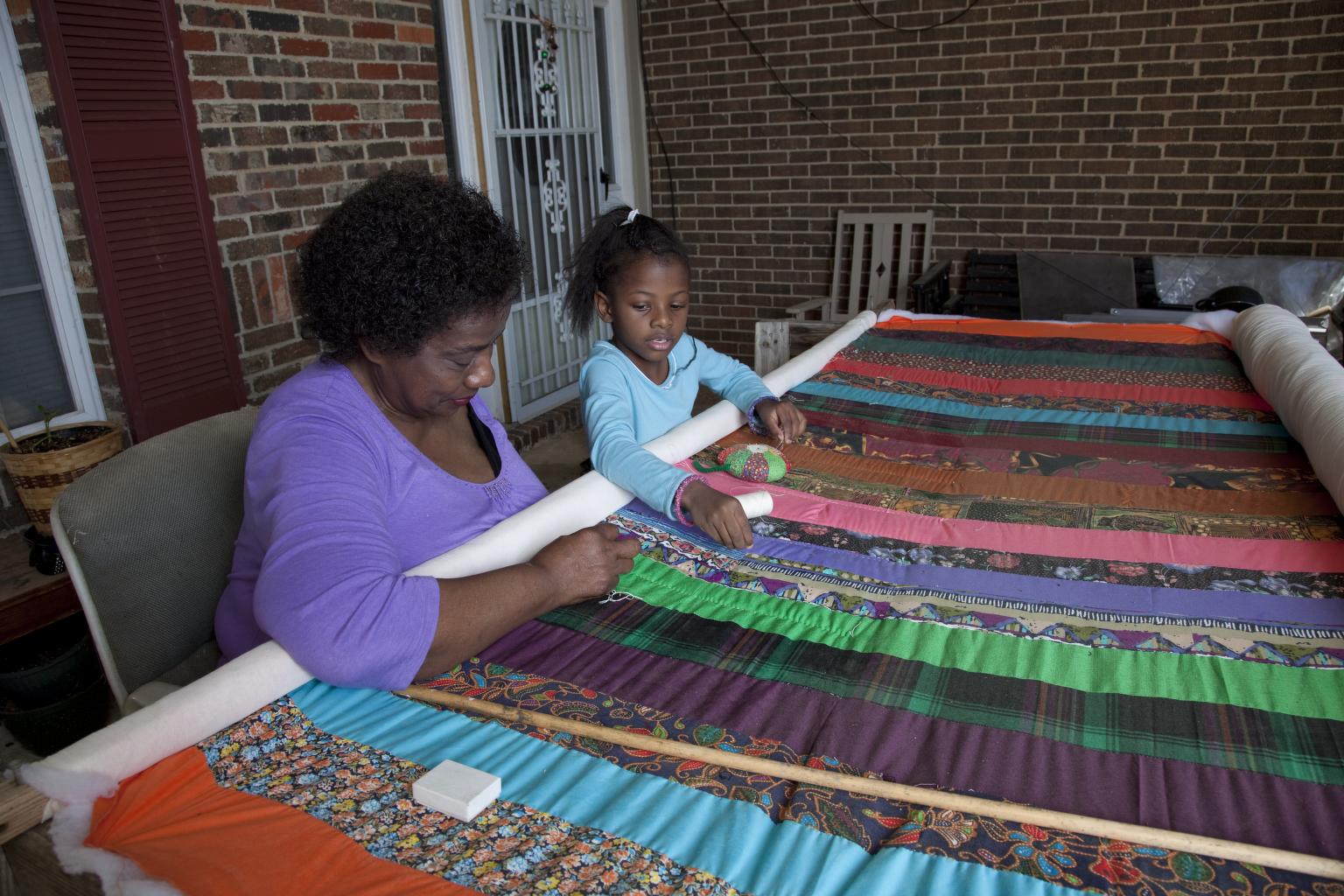 Woman and young girl working on a quilt