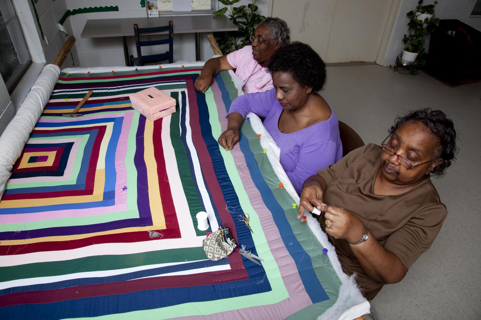 Three women working on a quilt